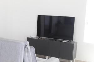 a flat screen tv sitting on a black entertainment center at Recanto Mar & Sol in Canguaretama