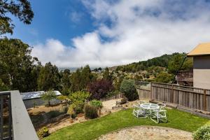 a patio with a table and chairs on a lawn at Entire Oceanview Coastal Retreat in Pacifica in Pacifica