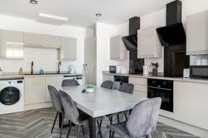 a kitchen with a table and chairs in a room at 5 Ensuite Bed Apartment in Prime Location in Nottingham