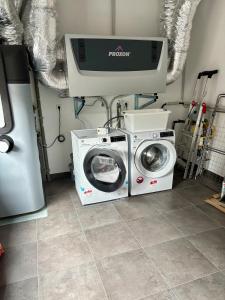 a washing machine and a dryer in a laundry room at Modern, new home with air cooling in Kindsbach