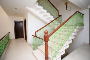 eine Treppe in einem Haus mit grünen und weißen Fliesen in der Unterkunft Collection O Sakshi in Manesar