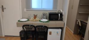 a kitchen with a table with two chairs and a microwave at Suíte Luxo na Casa 68 in Belém +10 photos