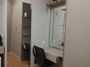 an office with a desk with a mirror and chairs at Suíte Luxo na Casa 68 in Belém