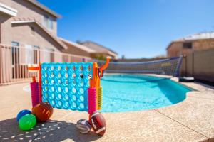 una piscina con un juego de damas y pelotas en Casa Desert Willow 5BR Home & Heated Pool, en Casa Grande