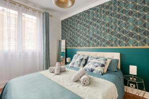 a bedroom with a blue bed with towels on it at Appart Cosy 4 Personnes - Parking Gratuit - Centre Paris 15 min Metro 4 in Bagneux
