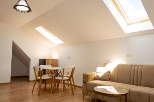 a living room with a couch and a table and chairs at Vila Mimoza in Sinaia