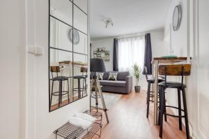 a living room with a couch and some bar stools at Appart Cosy 4 Personnes - Parking Gratuit - Centre Paris 15 min Metro 4 in Bagneux +15 photos