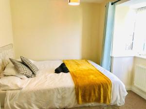 Un dormitorio con una cama con una manta amarilla encima. en Contractor Ready 4 Bed by EMA Ensuite Parking, en Castle Donington 2 fotos más