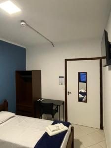 a bedroom with a bed and a desk and a table at Hotel do Baú in Santa Rosa de Viterbo