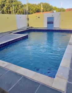an empty swimming pool with blue tiles on the water at Casa Ponta de Lucena Beach in Lucena