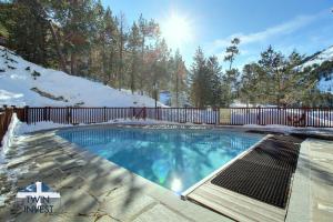 a swimming pool in the snow with a fence at ARC 1950 - Appartement 6 personnes - Départ ski aux pieds - Sauna, Hammam, Jacuzzi, Piscine chauffée in Arc 1950