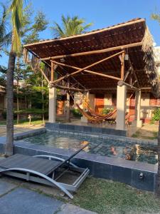 a swimming pool with a hammock in front of a house at Mar de Jeri in Jericoacoara