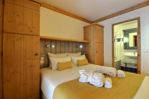 a bedroom with a large bed with towels on it at ARC 1950 - Appartement 6 personnes - Départ ski aux pieds - Sauna, Hammam, Jacuzzi, Piscine chauffée in Arc 1950 +22 photos