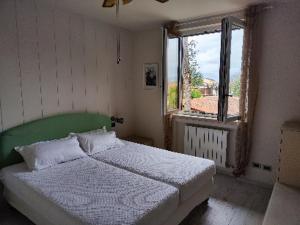 a bedroom with a bed with a green headboard and a window at Apartment Karol in Manerba del Garda