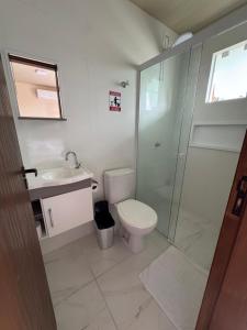 a bathroom with a shower and a toilet and a sink at Residencial Lara 5 in Itapema