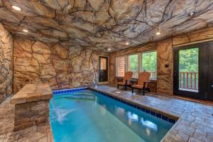 a large indoor pool with a stone wall at Summit View By Avada Properties in Waldens Creek