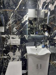 a black and white bathroom with a sink and a toilet at River Side Apartment in Prizren