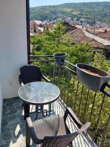 a patio with a table and chairs on a balcony at River Side Apartment in Prizren +10 photos