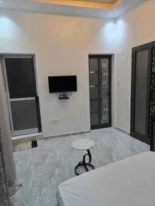 a bedroom with a bed and a tv on the wall at SUITE RESIDENCE TERANGAWALo in Richard Toll