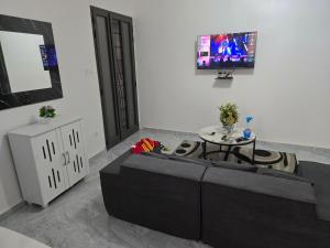 a living room with a table and a tv on a wall at SUITE RESIDENCE TERANGAWALo in Richard Toll
