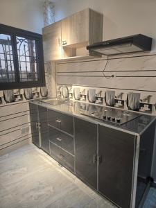 a kitchen with stainless steel cabinets and a stove at SUITE RESIDENCE TERANGAWALo in Richard Toll +1 photo