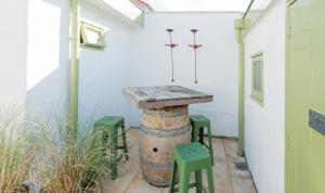 a table on top of a barrel with two green stools at Hanzestekje Harderwijk in Harderwijk