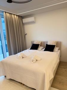 キェルツェにあるSmart Apartのタオルが敷かれた大きなベッドのある寝室