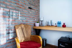 a rattan chair sitting next to a brick wall at Guesthouse Iago's Winery in Gorovani