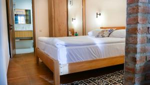 Schlafzimmer mit einem großen weißen Bett und einem Spiegel in der Unterkunft Guesthouse Iago's Winery in Gorovani