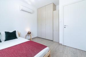 ニコシアにあるSunny & Stylish City Centre Livingの白いベッドルーム(ベッド1台、クローゼット付)