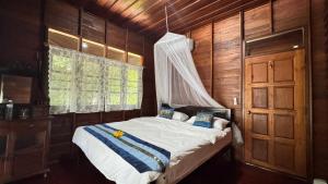 a bedroom with a bed with a mosquito net at Was Na Yajai 