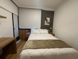 a bedroom with a large bed and a large window at Flat poeta Drumond in Sao Paulo