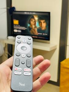 a hand holding a remote control in front of a tv at Taksim Precious Gold hotel in Istanbul