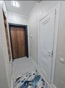 a white room with a door and a tile floor at Аренда квартир in Bishkek