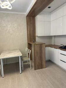 a kitchen with a table and a table and a chair at Аренда квартир in Bishkek