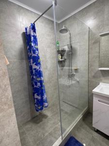 a bathroom with a shower with a blue shower curtain at Аренда квартир in Bishkek