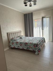 a bedroom with a bed with a floral bedspread at Аренда квартир in Bishkek