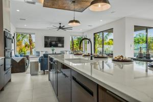 an open kitchen with white countertops and a living room at Knot A Basic Beach House in Bailey Hall