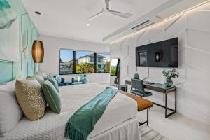 a bedroom with a bed and a desk and a television at Knot A Basic Beach House in Bailey Hall