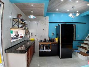 una cucina con frigorifero nero e pareti blu di Casa em Belém Para a COP 30 a Belém Altre 7 foto