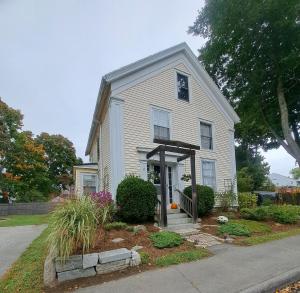 a white house with a porch and a driveway at Captain Hugo's Guesthouse in Rockland