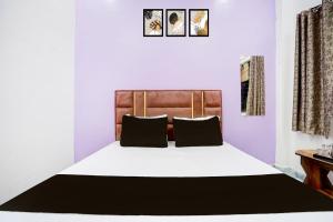 a bedroom with a large bed with two pillows at Hotel O MN Palace in Jabalpur