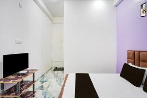 a bedroom with a bed and a tv and a table at Hotel O MN Palace in Jabalpur +21 photos