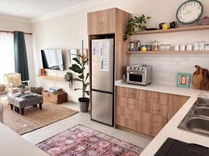 a kitchen with a stainless steel refrigerator and wooden cabinets at Fountain on the Fairway in Middelburg
