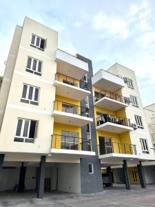 a tall white building with balconies at Noir & Blanc Suite in Mama