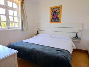 a bedroom with a white bed with a blue blanket at VV Casa Matilde "by henrypole home" in Valsequillo