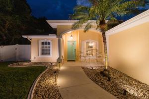 a palm tree in front of a house with a green door at La Dolce Vita in North Port