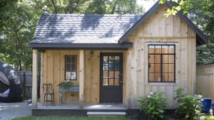 un petit abri en bois avec une porte noire dans l'établissement The Loon And The Wren, à Cape May Point