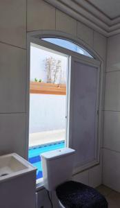a bathroom with a window and a toilet and a sink at Casa Di Malu Pousada Boutique in Sao Paulo