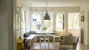 une cuisine avec une table, des chaises et des fenêtres dans l'établissement The Loon And The Wren, à Cape May Point